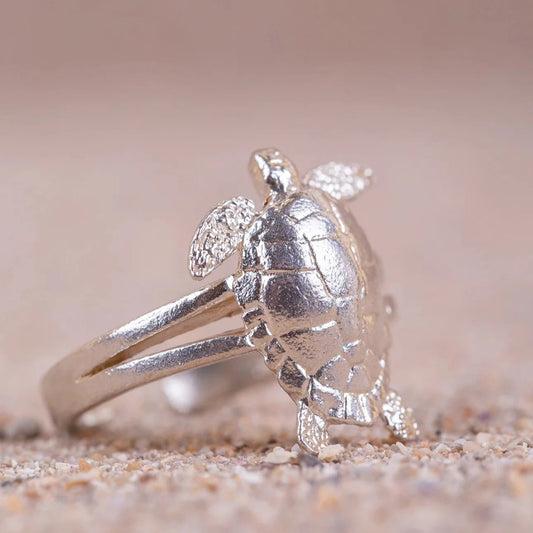Anillo de Tortuga (Cayume) en Plata de perfil con fondo de arena.