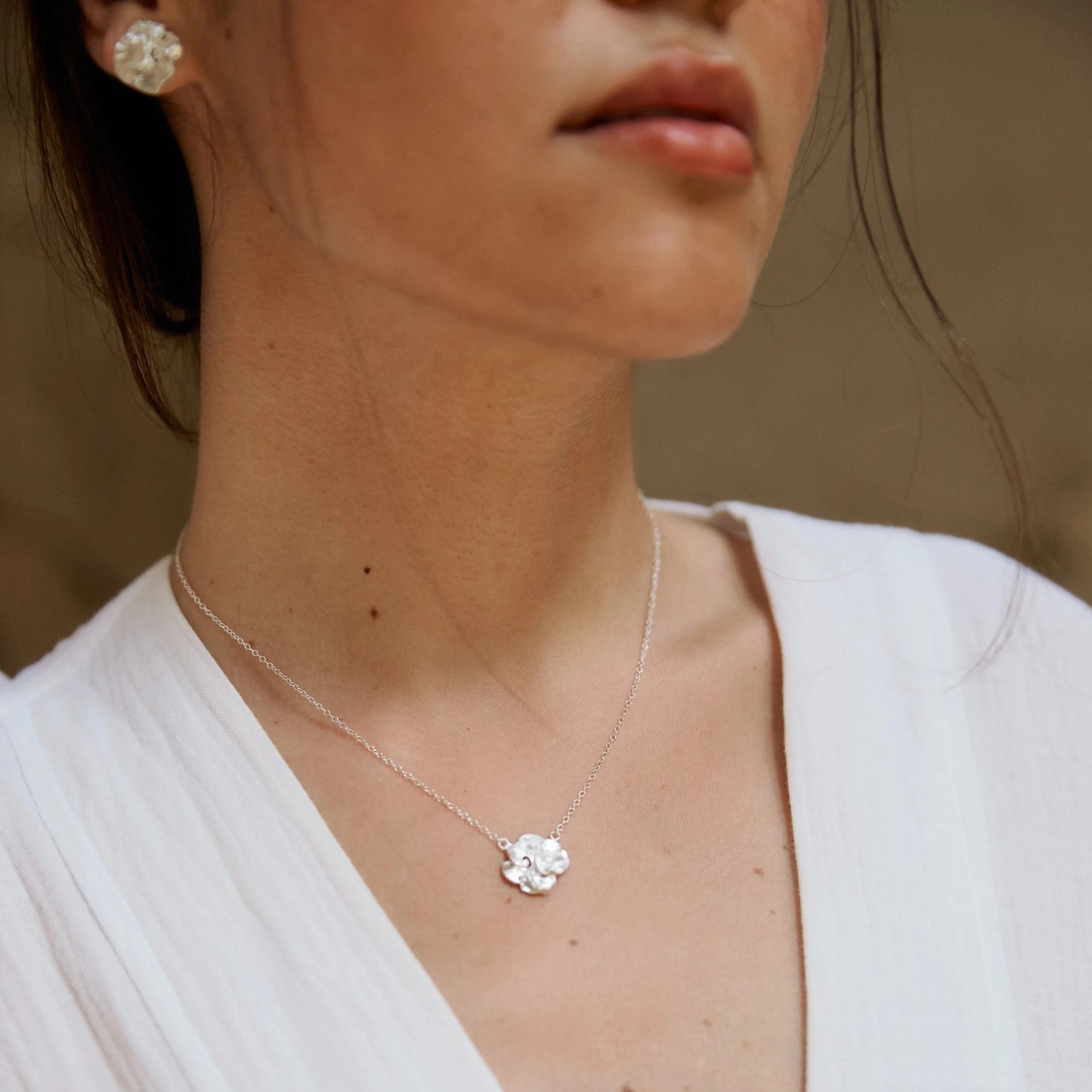 Modelo morena luciendo el colgante solitario de Pétalo en plata.