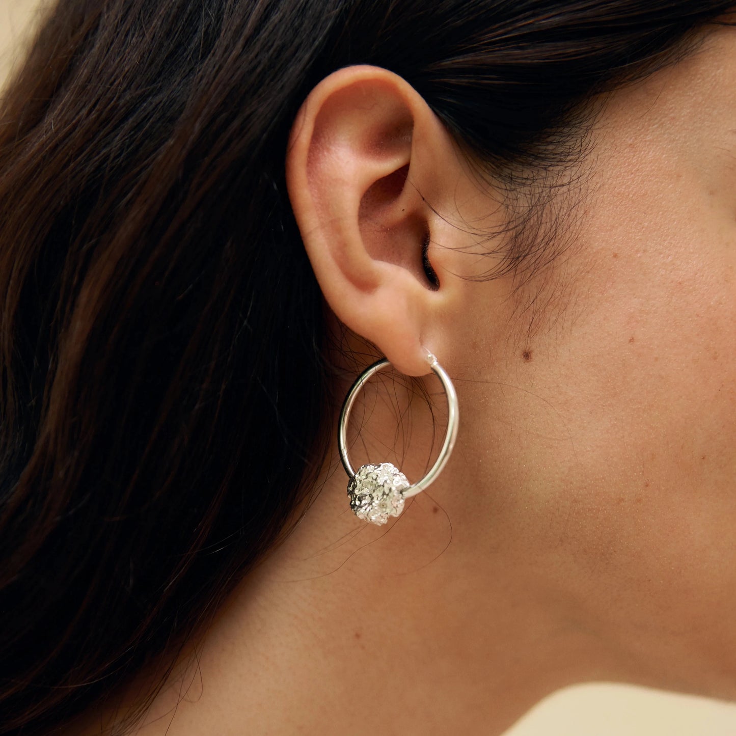 Modelo con pelo recogido, detalle de la oreja luciendo el Aro de Esponja de Plata.