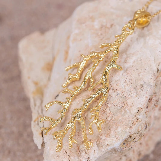 Detalles en macro del Colgante Gorgonia bañado en Oro con cadena de 40cm sobre roca blanca.
