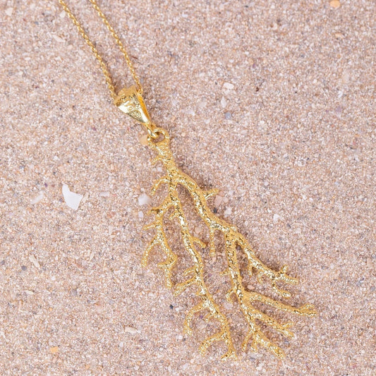 Detalles en macro del colgante de Gorgonia bañado en Oro con cadena de 70cm sobre arena.