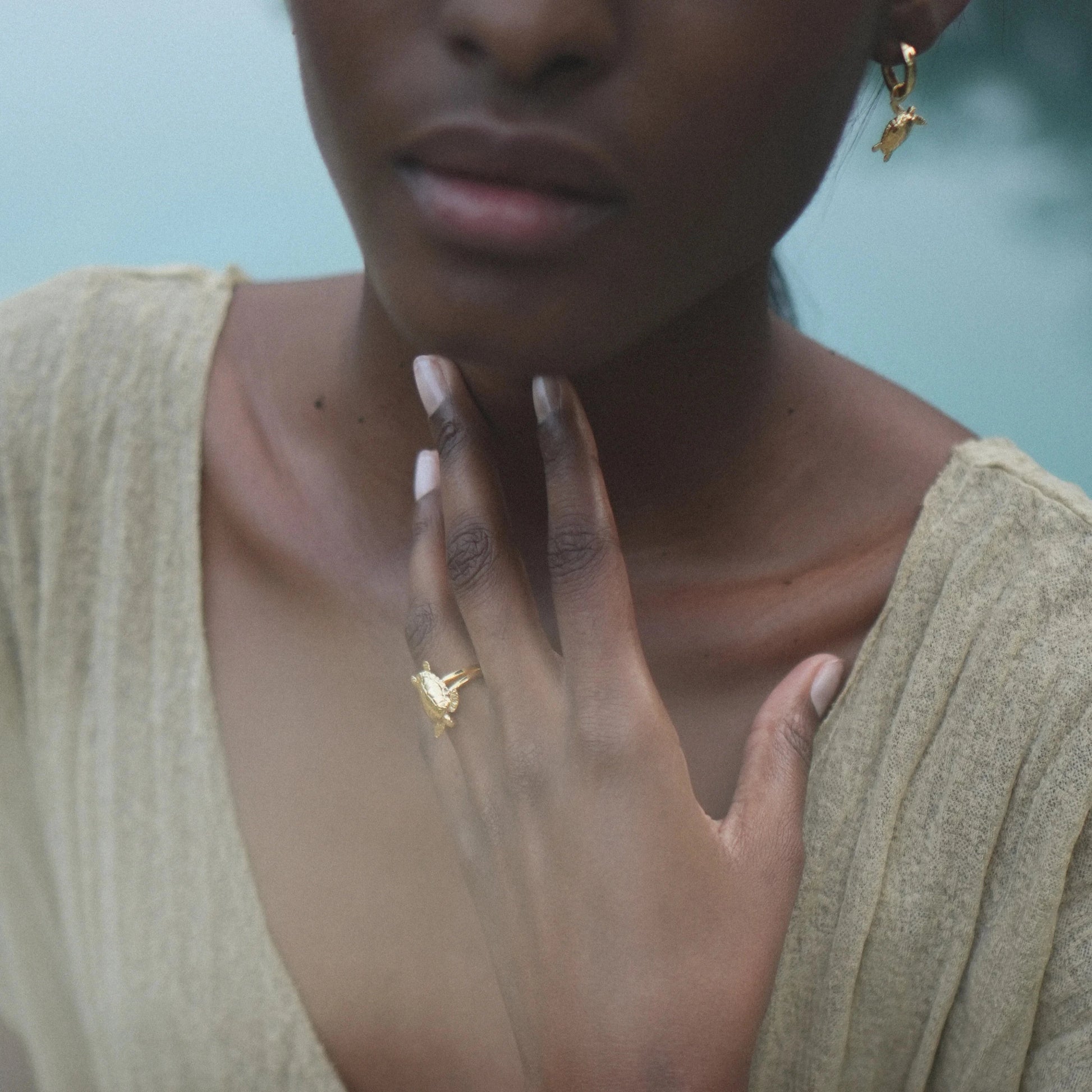 Modelo tocándose la barbilla con el Anillo de Cayume bañado en Oro.
